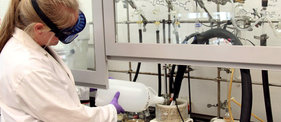 Photo of a chemist testing sythesis equipment for green chemistry.